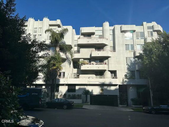 Front view of a multi-story apartment building with balconies.