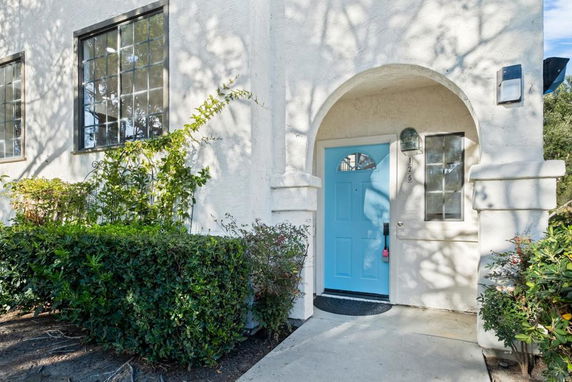 Front view of a house with a blue door and arched entrance.