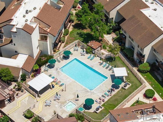 Aerial view of a residential swimming pool area surrounded by buildings.