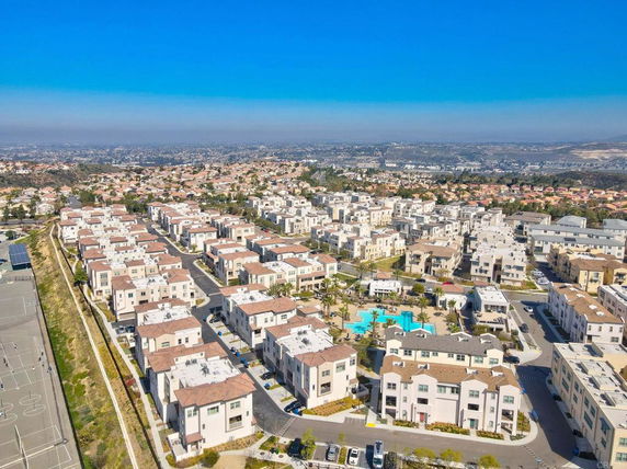 Aerial view of a residential area with multiple houses and a pool.