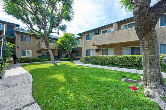 View of a two-story apartment building with a central courtyard.