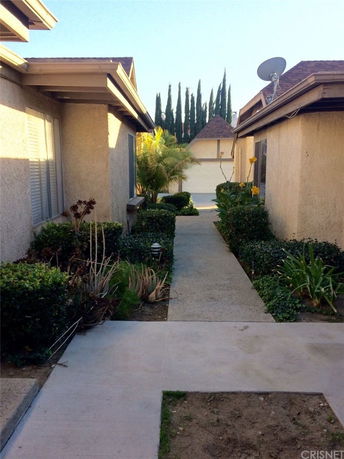 View of surrounding areas with two buildings and a path leading between them.