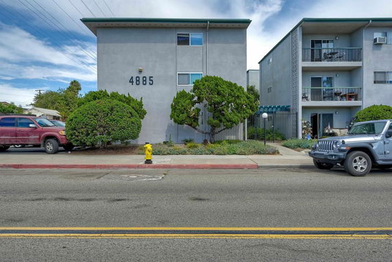 Front view of a multi-story apartment building with balconies.