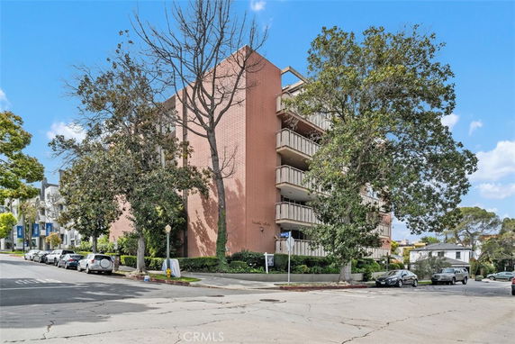 Front view of a multi-story brick building with balconies.