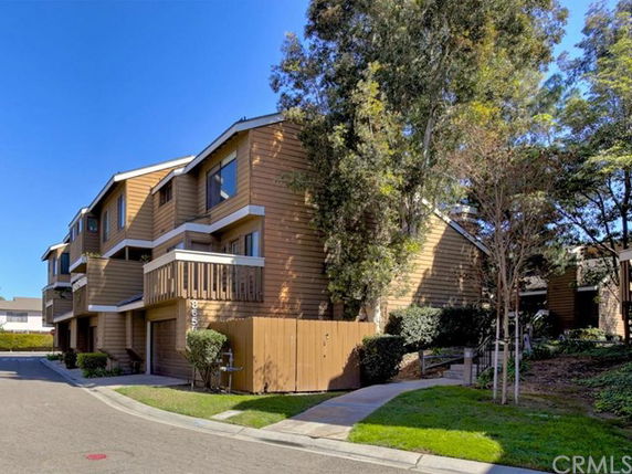 Side view of a multi-story wooden residential building with balconies.