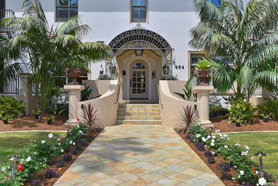 Front view of a building entrance with steps and ornamental plants.
