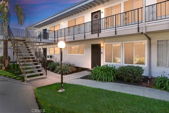 Front view of a two-story building with an exterior staircase and walkway.