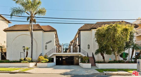 Front view of a multi-story building with a central entrance and tiled roof.