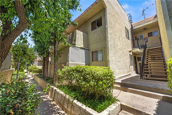 Front view of a two-story apartment building with outdoor stairs.