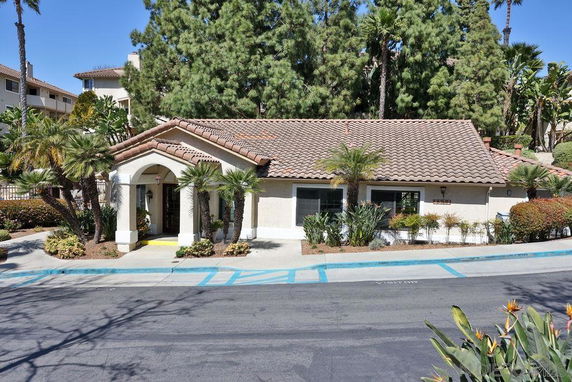 Front view of a single-story building with arched entrance and a tiled roof.