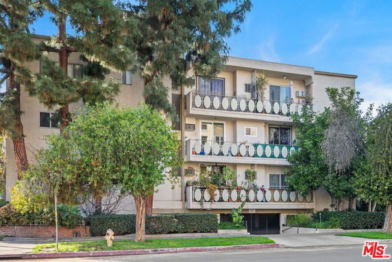 Front view of a multi-story apartment building with balconies.