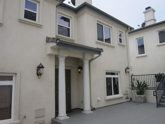 Front view of a two-story house with columns and multiple windows.