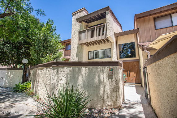 Front view of a two-story house with a small balcony and double entrance doors.