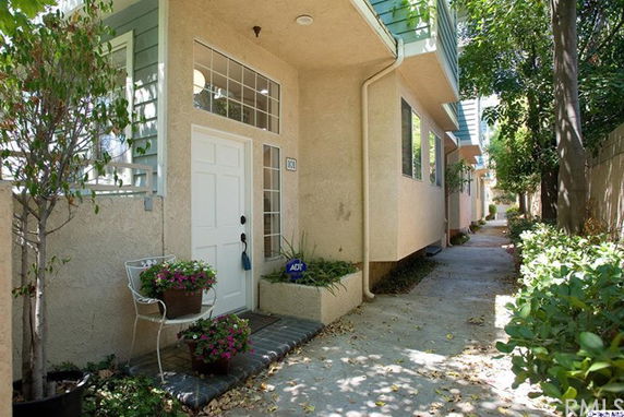 Front view of a house with a white door and large windows above it.