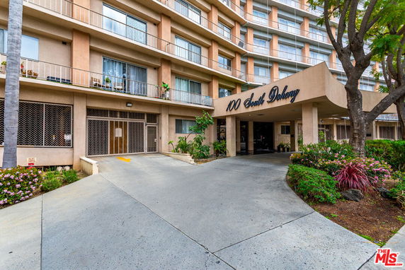 Front view of a multi-story building with balconies and a prominent entrance.