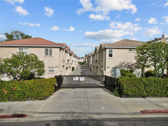 Front view of a gated residential complex with two-story buildings.
