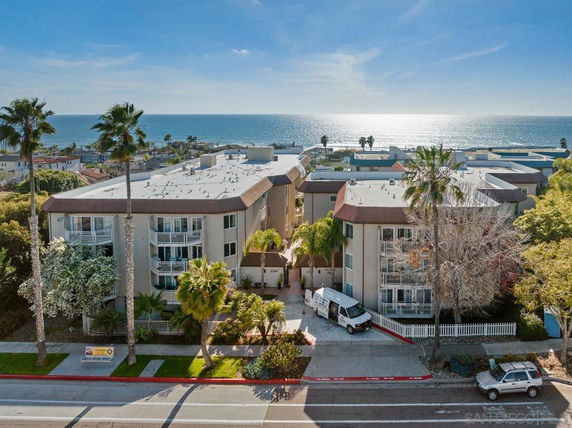 Front view of a multi-story apartment building near the ocean.