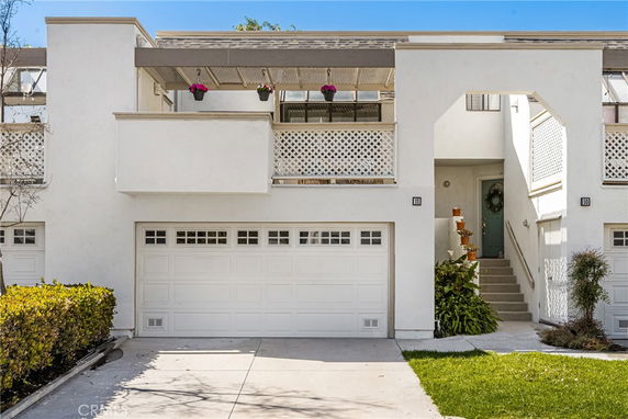 Front view of a townhouse with a balcony and double garage.
