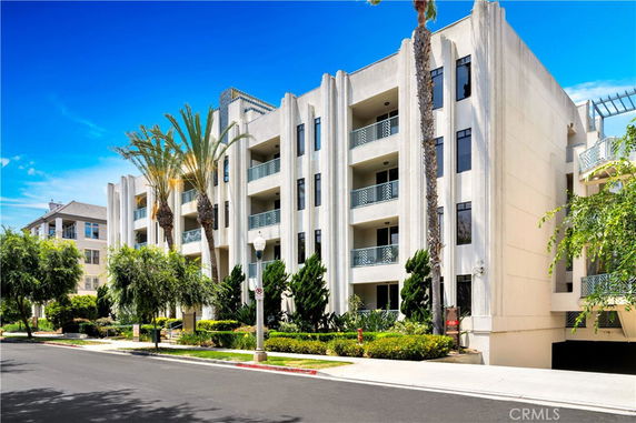 Front view of a multi-story apartment building with balconies.