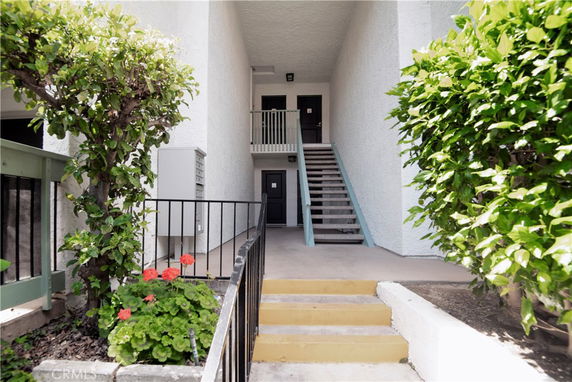 Exterior view of a building entrance with stairs leading to upper levels.