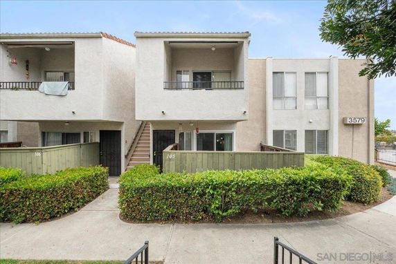 Front view of a two-story residential building with balconies and entrances.