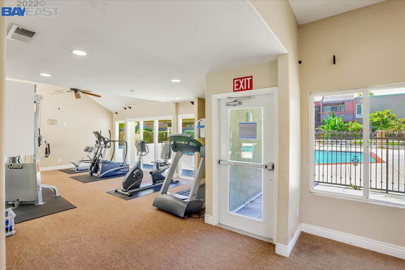 Indoor gym area with exercise equipment and exit door.