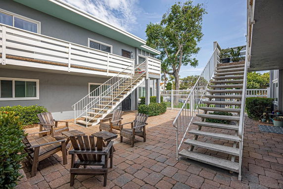 Outdoor view of a two-story building with staircases and balconies.