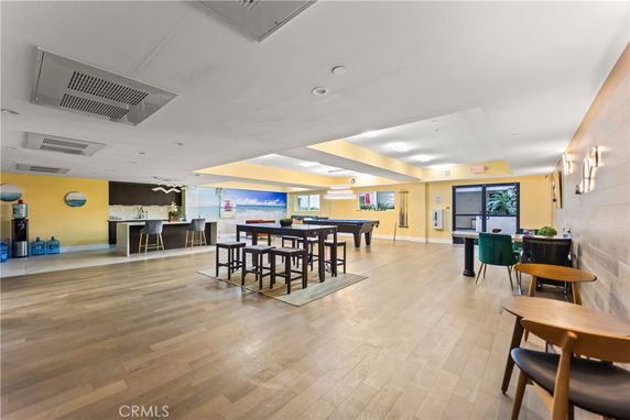 Recreation area with a pool table, bar counter, and seating arrangement.