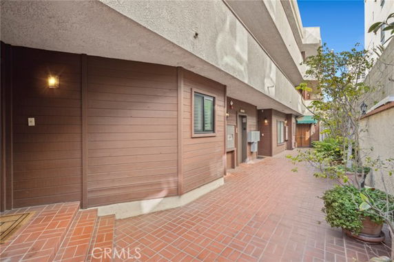 View of a multi-story building with brick flooring and brown siding.