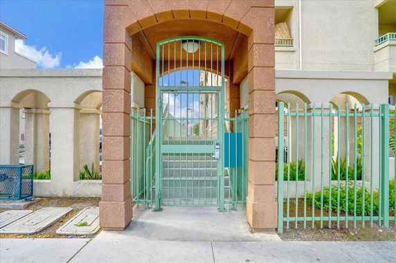 Front entrance view of a building with a gated entry and archway.