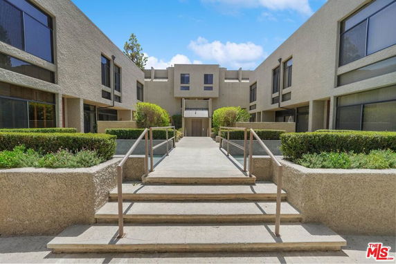 Front view of a multi-story building with symmetrical design and large windows.