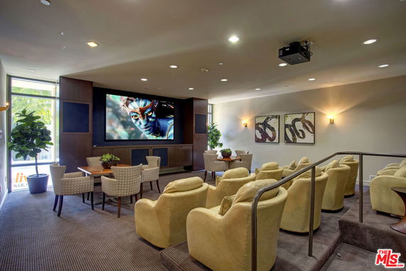 Indoor club house area with tiered seating and a large screen.