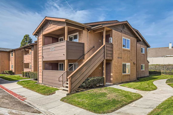 Front view of a multi-unit apartment building with external stairs.