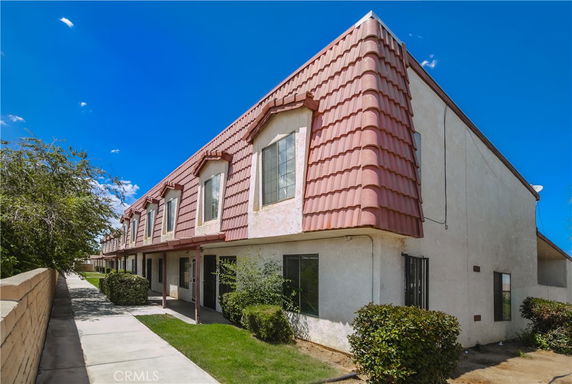 Front view of a two-story residential building with a unique sloped roof design.