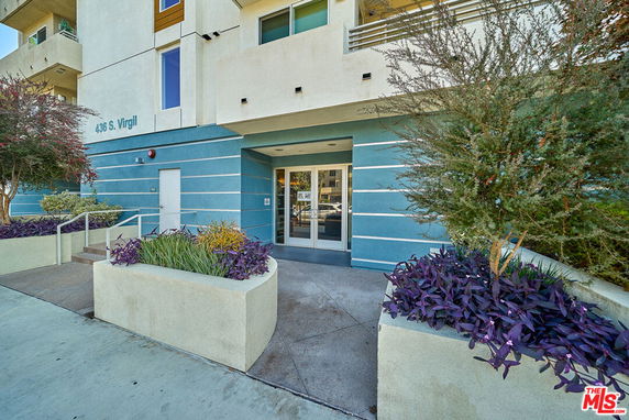Front view of a building entrance with a blue and beige exterior.