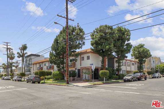 Front view of a two-story residential building with a tiled roof and arched entrance.