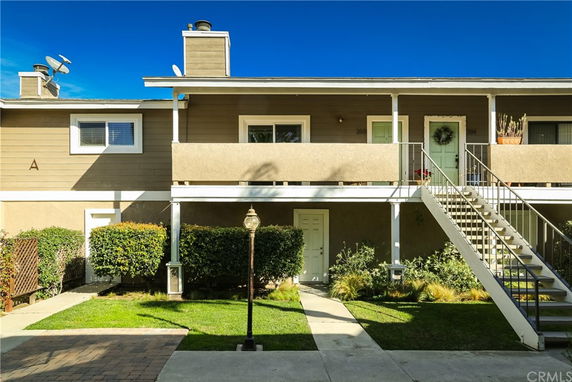 Front view of a two-story residential building with external staircase.