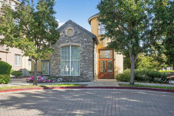 Front view of a house with a stone facade and large window.
