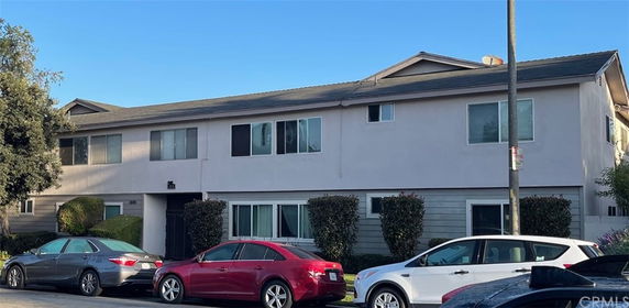 Front view of a two-story residential building with multiple windows and a sloped roof.