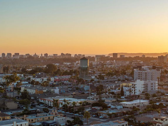 Wide angle view of city buildings and skyline at sunset.