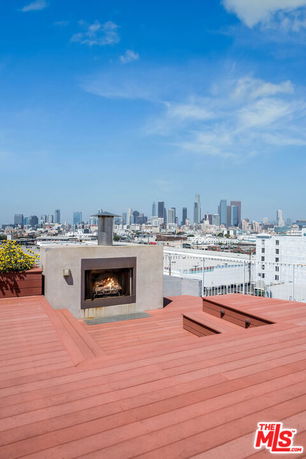 Rooftop view showing a fireplace and city skyline in the background.