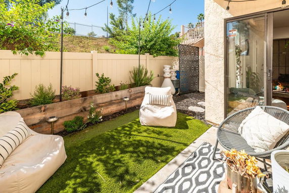 Outdoor seating area with artificial grass and string lights.