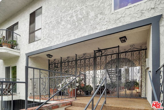 Front view of a building with decorative metal gate and staircase.