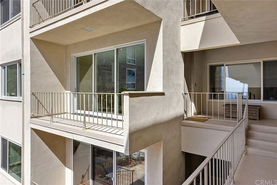 Elevation view of a building with balconies and large glass sliding doors.