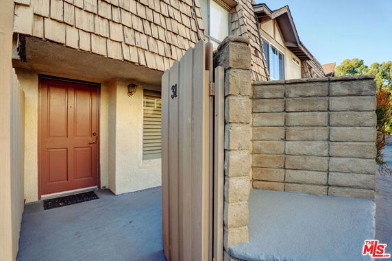 Front view of a house with a brown door and brick siding.