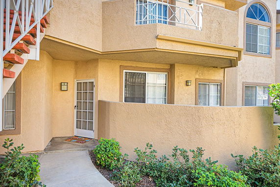 Front entrance of a residential building with a balcony above.