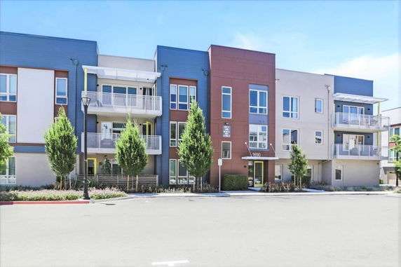 Front view of a modern multi-story apartment building with balconies.