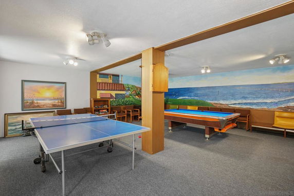 Indoor recreation room with a ping pong table and pool table.