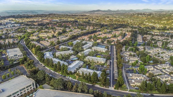 Aerial view of a suburban neighborhood with houses, roads, and greenery.