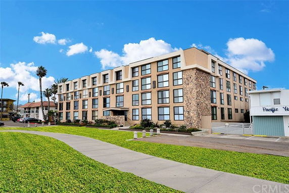 Front view of a multi-story building with large windows and a stone facade.